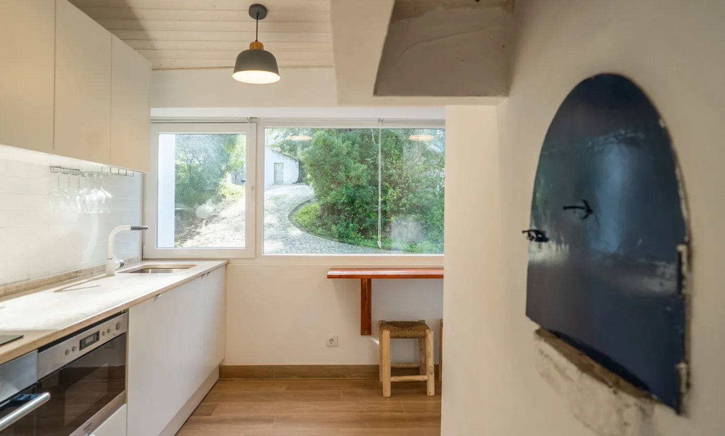 Photo of the kitchen catching the door of the wood stove of the Wood Oven I house